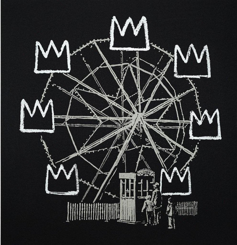 Image of an artwork by Banksy titled Banksyquiat, inspired by Basquiat but with Banksy's signature Street art style. It features a large ferris wheel with hand-painted crowns replacing each seat on the wheel. The image is white on a black background