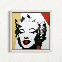 image of an artwork by andy warhol titled 'golden marilyn 37' in a white frame. the artwork features a stencilled image of marilyn monroe's face in black, on a background of white, red, and gold. this is a sunday b morning print