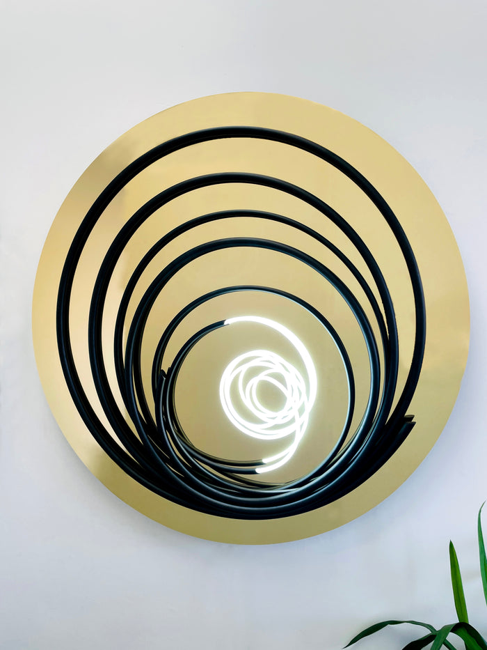 Add a touch of brilliance to your space with Mark Beattie's White Neon in Black Spiral, a unique sculpture featuring white neon and painted copper on gold mirror acrylic. This one-of-a-kind masterpiece, with a diameter of 120cm, creates a captivating interplay of light, texture, and contemporary design. Illuminate your surroundings with the artistic brilliance of White Neon in Black Spiral, a unique addition to any collection.