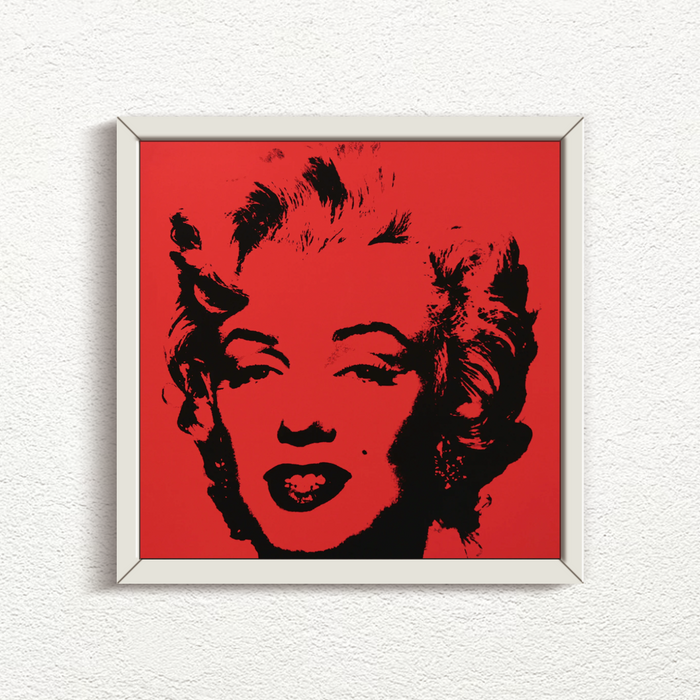 an image of an artwork by andy warhol titled 'Golden Marilyn 43' in white frame. the artwork features a black stencilled image of the face of marilyn monroe on a red background. this is a sunday b morning print