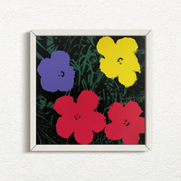 this is an image of a sunday b morning print after andy warhol artwork titled 'flowers 11:73' in a white frame. the artwork features four flowers atop a grassy background. the background is green and black, with the flowers in blue, yellow, and red. this is a sunday b morning print for sale