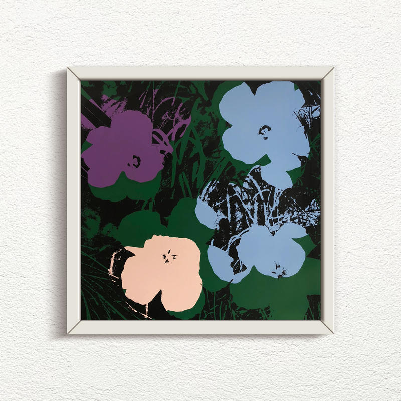 an artwork by andy warhol titled 'flowers 11:64' in a white frame, printed by sunday b morning. the artwork features four flowers on a green and black background, with the four flowers being purple, blue, and cream in colour. this is a sunday b morning print for sale