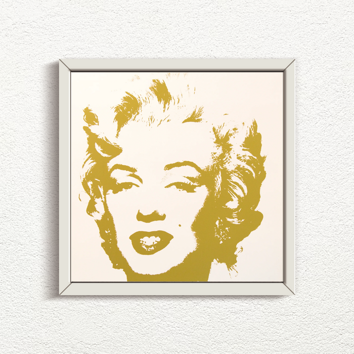 an image of an artwork by andy warhol titled 'golden marilyn 41' in white frame.  the artwork features a stencilled image of marilyn monrow's face in gold on a white background. this is a sunday b morning print