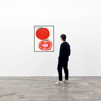 a photo of a david shrigley art print in a black frame, hung on a white wall in a viewing space, with a single spectator to the right of the framed piece.. the print features two large images of the outside of a tomato as well as the inside of a tomato, with small text in the top left stating 'IF YOU DON'T LIKE TOMATOES', and more small text in the bottom right corner stating 'YOU CAN FUCK OFF'. david shrigley prints david shrigley posters david shrigley art