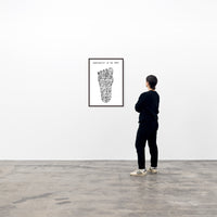 a photo of a framed art print by david shrigley hanging on a wall, being viewed by a spectator. the art print depicts a foot made out of doodled smiley faces and swirls, and text at the top of the page stating 'COMPLEXITY OF THE FOOT'. buy david shrigley prints, david shrigley art, david shrigley prints, david shrigley art prints, david shrigley for sale uk, david shrigley posters, shrigley posters, shrigley prints