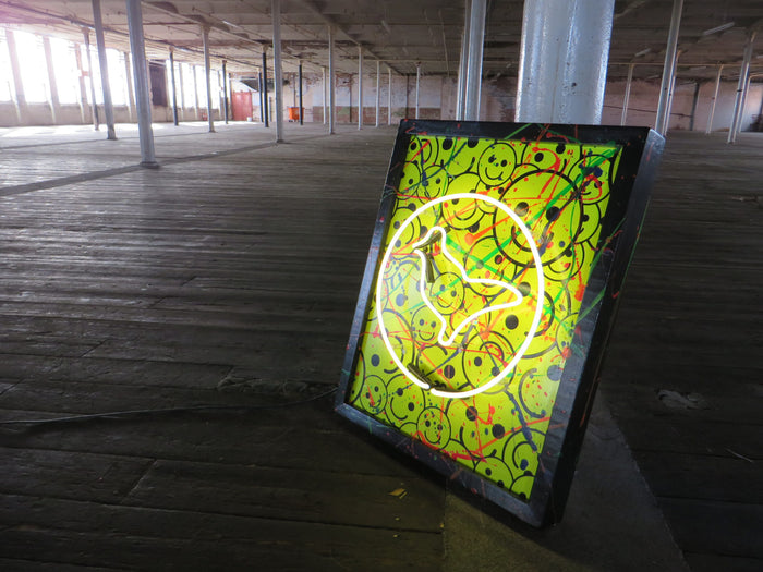 Elevate your space with the playful charm of Tony Spink's Dove With Smileys. This one-of-a-kind artwork features white neon on a wooden panel adorned with vinyl smiley faces and vibrant paint splashes, elegantly framed in black wood. Measuring 61 x 76 cm, this original masterpiece is a unique fusion of white neon art and lively design. Make a statement with this distinctive neon artwork, a dynamic addition to any art collection.