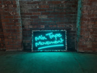 Experience the nostalgia of Mix Tape Movement by Tony Spink. This one-of-a-kind artwork features turquoise neon on a wooden backing panel painted black, adorned with a collage-style frame depicting mix tapes. Measuring 60 x 98 cm, this original masterpiece is a unique fusion of neon art and musical nostalgia. Elevate your space with this distinctive neon artwork capturing the essence of the mix tape era in a warehouse 