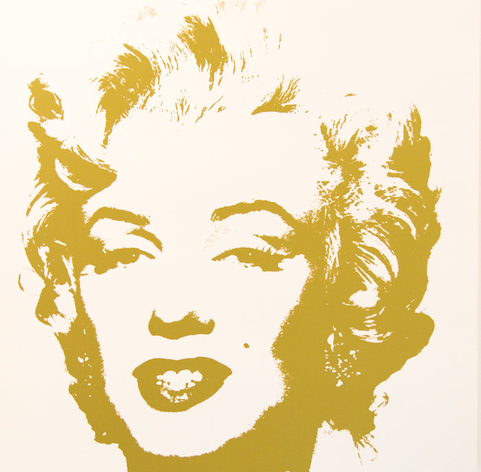 an image of an artwork by andy warhol titled 'golden marilyn 41'.  the artwork features a stencilled image of marilyn monrow's face in gold on a white background. this is a sunday b morning print