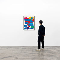 a photo of a david shrigley art print in a black frame, hanging on a wall with a single spectator to its right looking upon it. the print features a large red heart in the centre, with childlike painted clouds and other coloured hearts superimposed onto it. at the top, there is very small, handwritten text reading 'I WISH THE CLOUDS WERE NOT THERE BUT THEY ARE AND I MUST ACCEPT IT'. david shrigley prints, david shrigley art