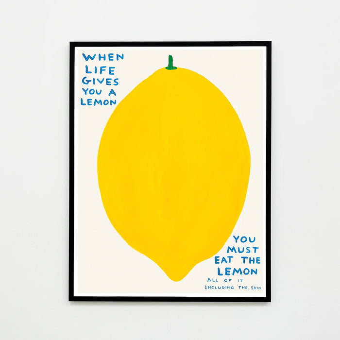 An image of an artwork by David Shrigley titled 'When Life Gives You A Lemon' in a black frame. The piece features a large, cartoon-like depiction of a lemon, with text at the top right stating 'WHEN LIFE GIVES YOU A LEMON', and in the bottom right continuing 'YOU MUST EAT THE LEMON', 'ALL OF IT', 'INCLUDING THE SKIN'. This is a David Shrigley Poster or Print