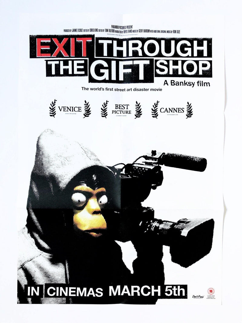 This is an image of a promotional poster for 'EXIT THROUGH THE GIFT SHOP', a film by Banksy. The poster features a large image of a monjey in a hood holding a film camera, and the title 'EXIT THROUGH THE GIFT SHOP'.