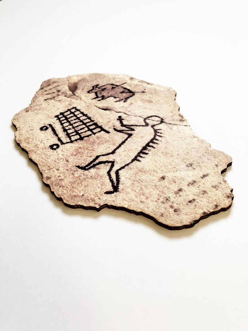 This artwork by Banksk titled Peckham Rock contain a cave painting of a human pushing a shopping trolley whilst huniting a boar which has two arrows in it providing satirical humour 